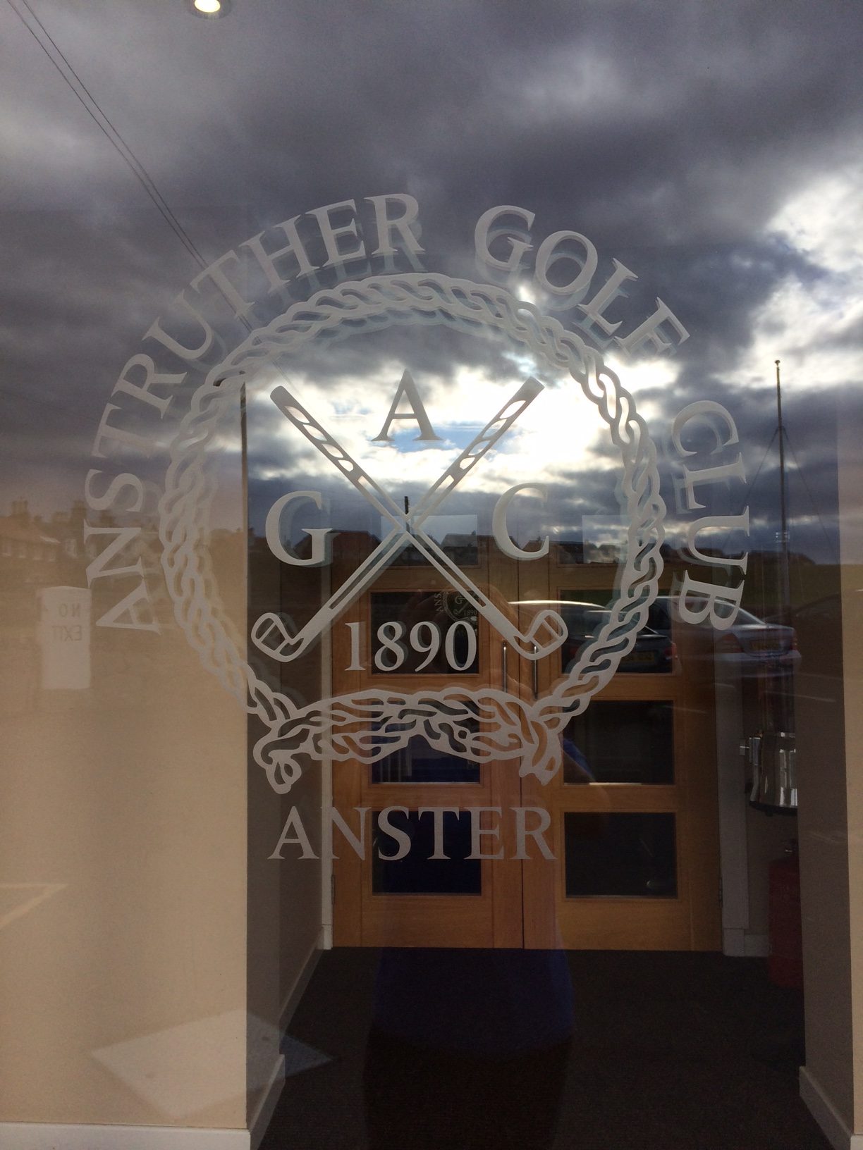 Anstruther golf club logo on the glass clubhouse door